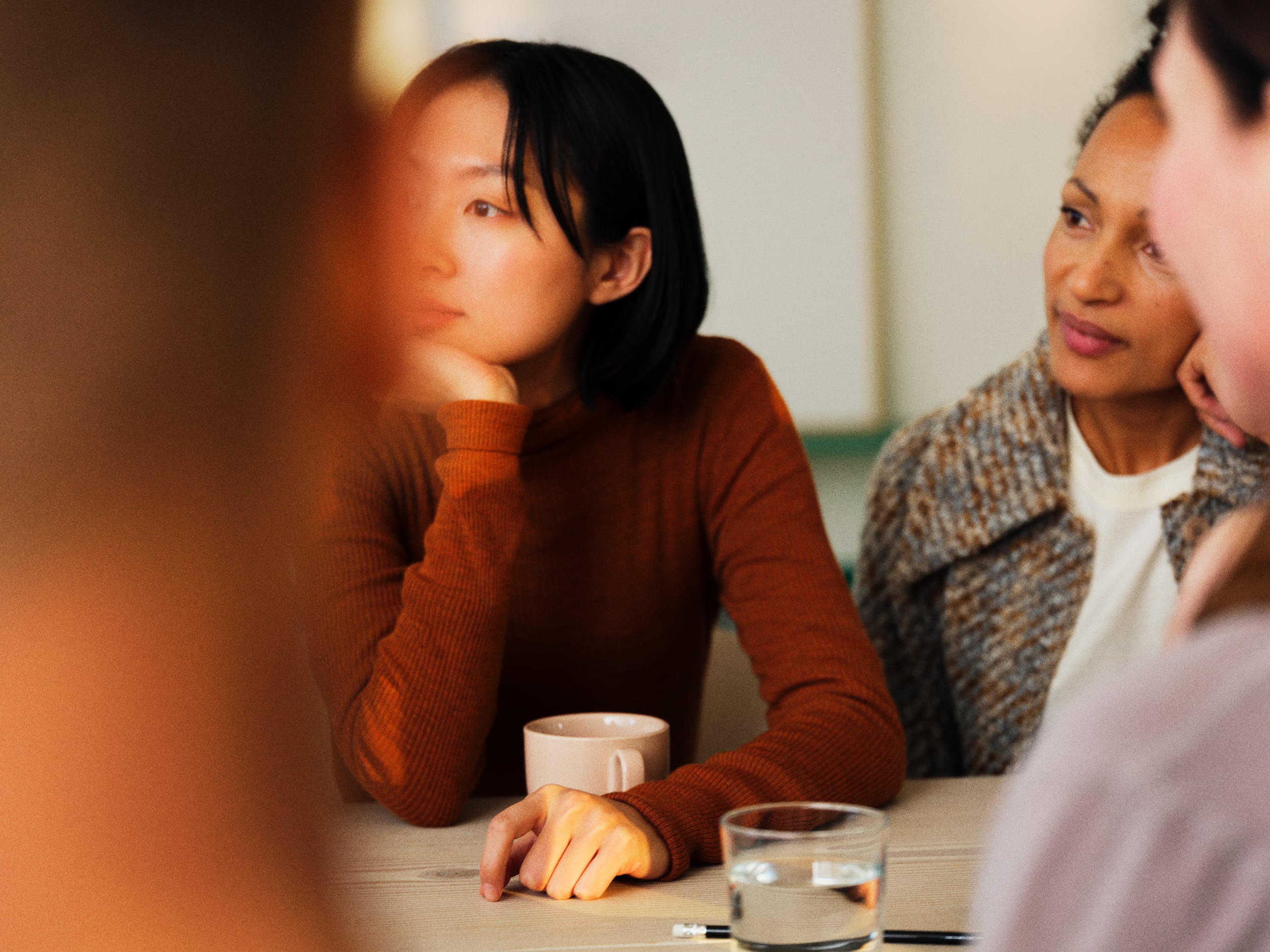 People close up, sitting around a table